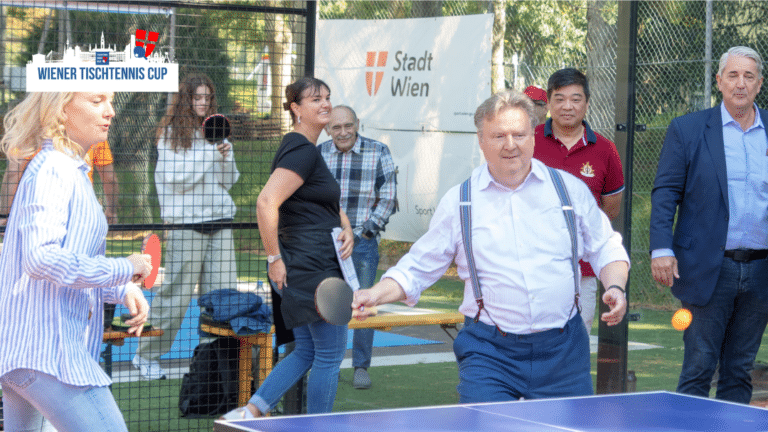 Bürgermeister Michael Ludwig in Aktion an der Tischtennisplatte beim Wiener Tischtennis Cup; er hält einen Schläger und hat sichtlich Freude am Spiel.