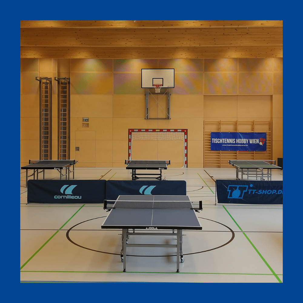Blick in die Tischtennis Halle des Vereins Tischtennis Hobby Wien: Mehrere professionelle Tischtennistische stehen spielbereit in einer hellen, weitläufigen Halle für das Training und die Bezirksliga bzw. für den Wiener Tischtennis Cup.