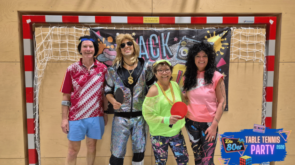 Teilnehmer der 80er Table Tennis Party in authentischen Retro-Outfits mit bunten Stirnbändern und Neon-Farben an einer Tischtennisplatte. Die Zeitreise-Stimmung wird durch stimmungsvolles Schwarzlicht und leuchtende Akzente in der Halle von Tischtennis Hobby Wien unterstrichen.