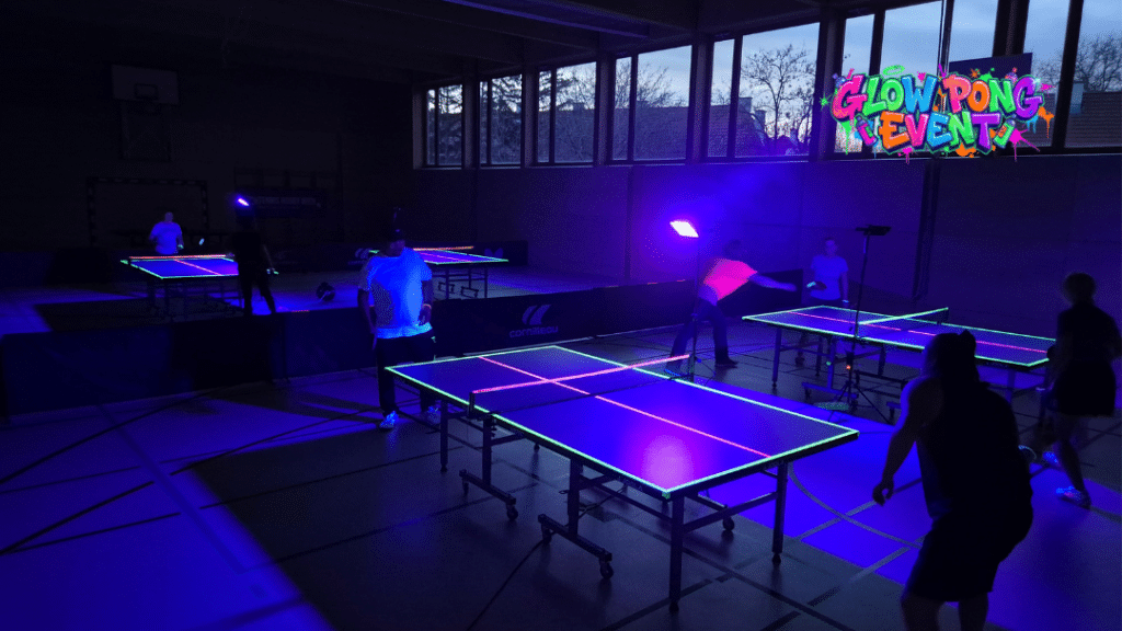 Rückblick auf das erste UV Ping Pong Event in Wien: Begeisterte Teilnehmerinnen und Teilnehmer spielen Tischtennis bei Schwarzlicht und Musik. Ein innovatives Hobby-Sport-Erlebnis von Tischtennis Hobby Wien zur Förderung der Gemeinschaft.